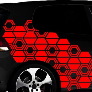May include: A black car with a red geometric pattern decal on the side. The pattern is made up of repeating hexagons.