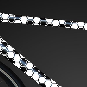 May include: A black and white bicycle frame with a honeycomb pattern. The frame is made of carbon fiber and has a sleek, modern design.
