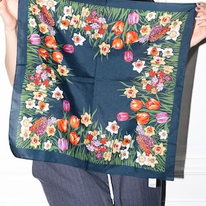 Può includere: Un foulard di seta verde scuro con una stampa floreale di tulipani e narcisi in tonalità di rosso, arancio, giallo e bianco.