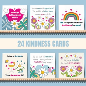 May include: A set of 24 kindness cards displayed on a shelf. Each card features colorful illustrations and positive messages, including phrases like "Always follow your heart" and "You deserve it!" The cards have a retro, whimsical design.