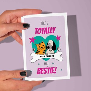 Tarjeta de amistad imprimible con la frase "Eres totalmente mi mejor amiga". ¡Linda tarjeta de felicitación con gatito y cachorro en un corazón! (fondo morado)