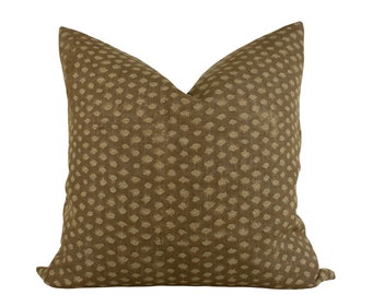 Può includere: Un cuscino marrone per divano con un motivo geometrico beige.