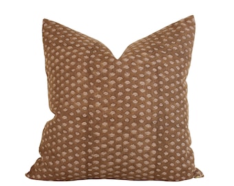 May include: A brown and beige patterned throw pillow with a subtle polka dot design.