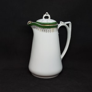 May include: White porcelain coffee pot with a green and gold trim. The pot has a lid with a decorative knob.