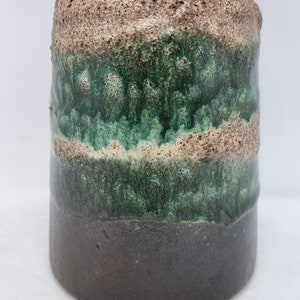Puede incluir: Un jarr&oacute;n de cer&aacute;mica con un esmalte marr&oacute;n texturizado, una banda de esmalte verde y una base marr&oacute;n oscuro.