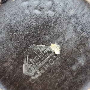 Puede incluir: Primer plano de la parte inferior de una olla de cer&aacute;mica marr&oacute;n con una marca dorada que dice "Wilhelm  Wacker  Barmen".