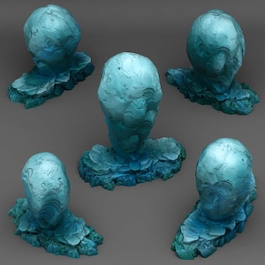 May include: Five abstract sculptures in shades of blue and teal. Each sculpture has a rounded, egg-like top and sits on a textured, rocky base. The pieces are arranged against a gray background, showcasing their unique forms and textures.