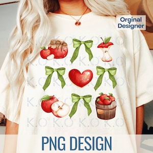 May include: A white t-shirt with a design of red apples, green bows, a jar of red jam, a red heart, and a basket of red apples. The text "PNG DESIGN" is at the bottom of the shirt.