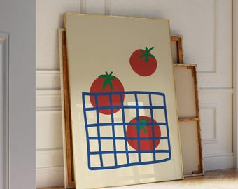 Op de afbeelding: Een ingelijste kunstdruk met een minimalistische illustratie van rode tomaten met groene stelen. De tomaten staan tegen een crèmekleurige achtergrond, met een blauw rasterontwerp. Het kunstwerk heeft een gouden lijst.