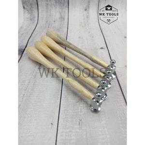 Könnte beinhalten: Fünf Kugelkopfhämmer mit Holzgriffen. Die Hämmer haben einen polierten Metallkopf und einen hellfarbigen Holzgriff. Der Text "WK TOOLS" ist auf dem Bild zu sehen. Die Hämmer sind diagonal angeordnet.