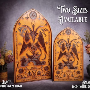 May include: Two wooden plaques with a dark brown background and gold accents. The plaques feature a stylized image of a goat-like figure with wings and horns. The text "AS ABOVE SO BELOW" is written on the plaques, along with the phrase "DO WHAT THOU WILL". The plaques are available in two sizes: 21cm wide x 37cm high and 16cm wide x 28cm high.