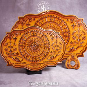 May include: A set of three wooden Ouija boards in varying sizes, with a planchette. The boards are tan with dark brown engraved details, including letters, numbers, and phrases. The text "TWO SIZES AVAILABLE" is at the bottom.
