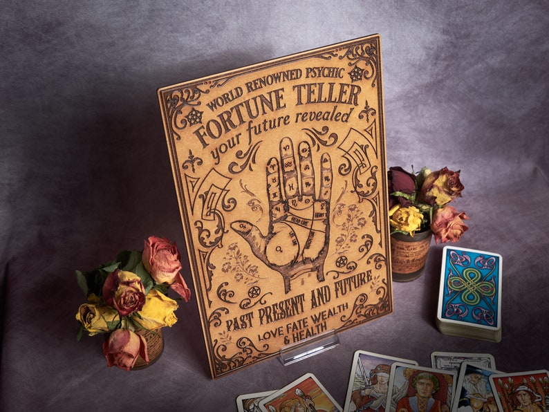 May include: A wooden sign with a vintage aesthetic, featuring a hand with lines and symbols, and the text "WORLD RENOWNED PSYCHIC FORTUNE TELLER your future revealed PAST PRESENT AND FUTURE LOVE FATE WEALTH & HEALTH".