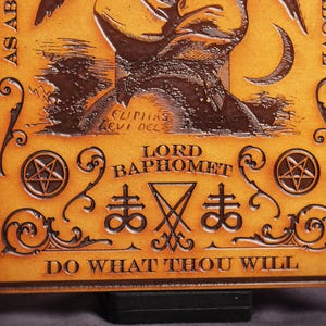 May include: A brown leather plaque with a pentagram and the words "Lord Baphomet" and "Do What Thou Wilt".