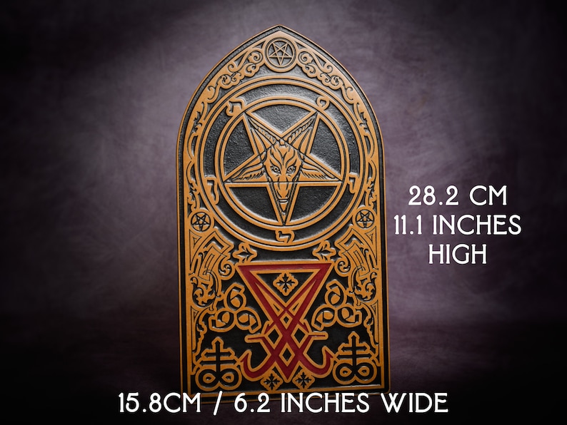 May include: A black and gold decorative plaque with a pentagram and other symbols. The plaque is 28.2 cm high and 15.8 cm wide.