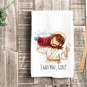 May include: White kitchen towel with a cartoon illustration of a figure carrying a large bottle of red liquid. The figure is giving a thumbs up and winking. Text on the towel reads "I GOT YOU, GIRL!"