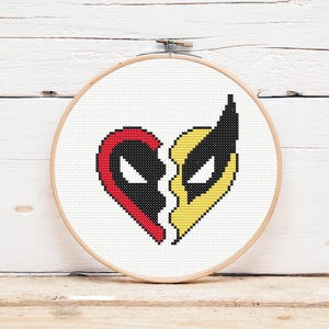 May include: Cross-stitch pattern of a heart split in half, with one side featuring a red and black Deadpool mask and the other side featuring a yellow and black Wolverine mask.