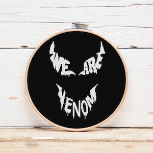 Puede incluir: Aro de bordado negro y blanco con las palabras "We Are Venom" en una fuente estilizada.