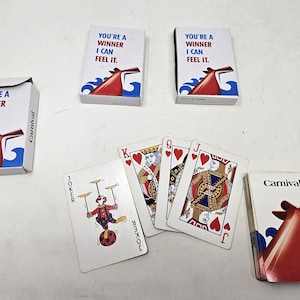 May include: Several decks of Carnival playing cards and individual cards are displayed. The card decks have the text "YOU'RE A WINNER I CAN FEEL IT." and a red and blue graphic. Individual cards include a Joker and various face cards.