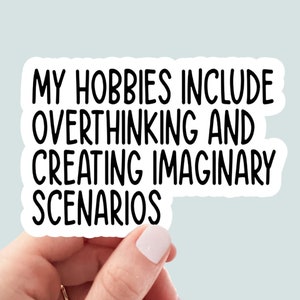 May include: White sticker with black text that reads "My hobbies include overthinking and creating imaginary scenarios."