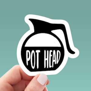 May include: A white sticker with a black outline of a coffee pot and the text "POT HEAD" in white.