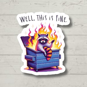 May include: A sticker featuring a raccoon sitting in a blue dumpster on fire. The raccoon is waving with its right paw. The text "WELL, THIS IS FINE." is above the raccoon.