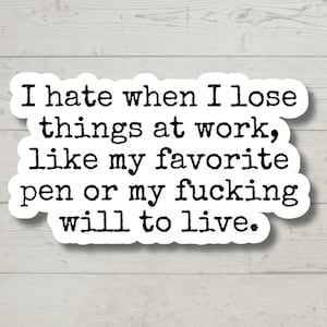 May include: A white sticker with black text that reads, "I hate when I lose things at work, like my favorite pen or my fucking will to live." The sticker has a white border and is on a light wood background.