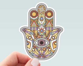 May include: A colorful hamsa hand sticker with intricate details and a large eye in the center. The sticker is on a light blue background.