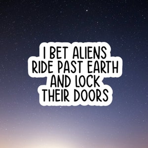 May include: A white sticker with black text against a dark blue background with white stars. The text reads "I bet aliens ride past earth and lock their doors."