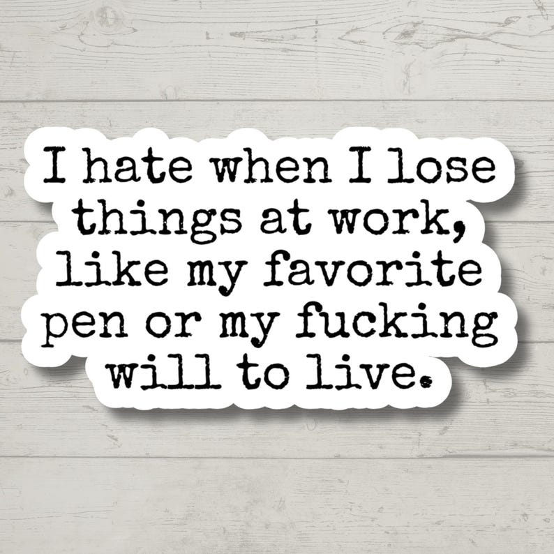 May include: A white sticker with black text that reads, "I hate when I lose things at work, like my favorite pen or my fucking will to live." The sticker has a white border and is on a light wood background.