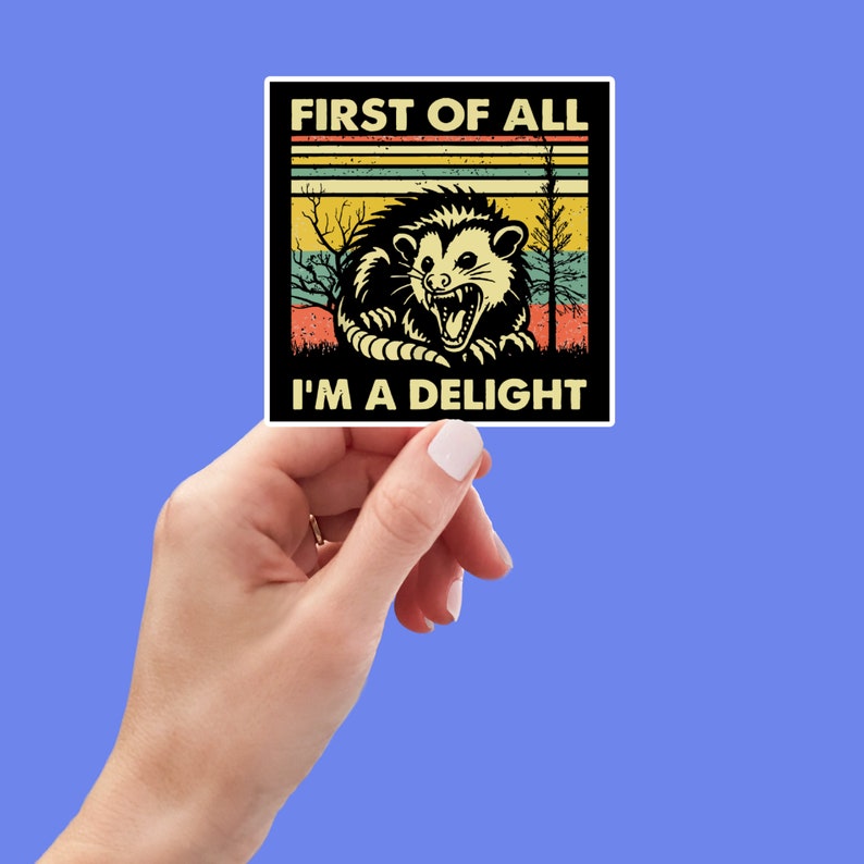 May include: A vintage-style sticker featuring a cartoon opossum with the text "First of all, I'm a delight". The background is a retro-style sunset with a yellow, orange, and red color scheme.