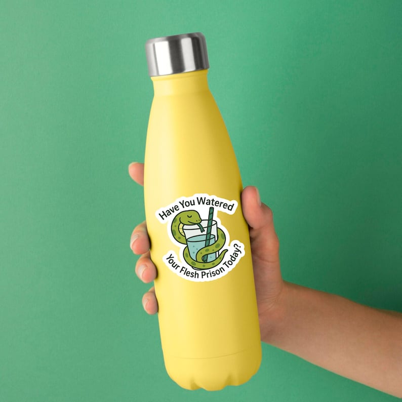 May include: A yellow insulated water bottle with a silver cap. A sticker on the bottle features a green snake wrapped around a glass of water with a straw, and the text "Have You Watered Your Flesh Prison Today?"