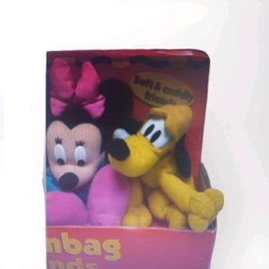 May include: A boxed set of plush toys featuring Minnie Mouse with a pink bow and Pluto the dog. The toys are yellow, pink, and black, with the text "Soft & cuddly friends" visible on the box.