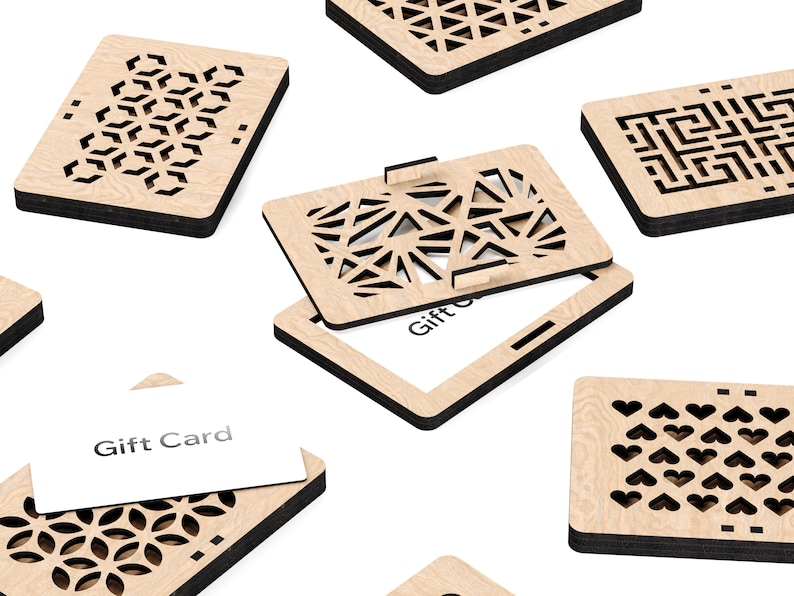 May include: A set of six wooden gift card holders with intricate laser-cut designs. Each holder features a different geometric pattern, including hearts, stars, and geometric shapes. The holders are made of light brown wood with black edges and have a slot for a gift card. The text "Gift Card" is visible on one of the holders.