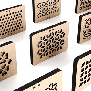 May include: Seven wooden plaques with different laser-cut geometric patterns. The plaques are light brown with black edges and are arranged in a staggered pattern on a white background.
