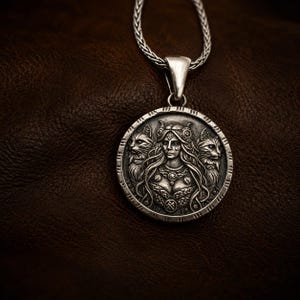 Silver pendant necklaces featuring a detailed relief of a woman with long hair, flanked by two cats. The pendant has the text "Freya Goddess" at the top.