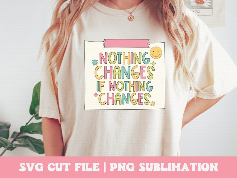 Puede incluir: Una camiseta blanca con un gr&aacute;fico rosa, amarillo, azul y verde que dice "Nada cambia si nada cambia". El gr&aacute;fico est&aacute; en una caja con una cinta rosa en la parte superior y una carita sonriente en la esquina.