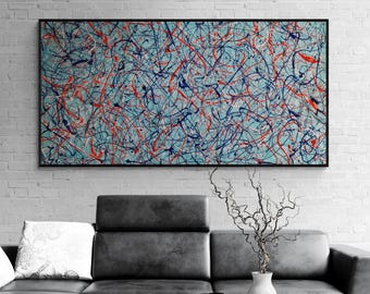 May include: A large rectangular wall art piece featuring an abstract expressionist design with chaotic, overlapping paint splatters in vibrant red, deep navy blue, and white, all set against a light blue background within a thin black frame.