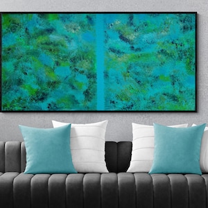 Puede incluir: Una pieza de arte mural rectangular con una composición abstracta de pinceladas mezcladas en azul cerceta, turquesa y verde lima, dividida por una línea vertical sólida en azul cerceta, dentro de un marco negro fino sobre un sofá gris oscuro.