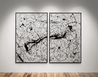 May include: Two framed abstract paintings. Each features a white background with black paint splatters and lines. The black paint creates a dynamic, chaotic pattern across the canvas. The frames are black.
