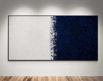 May include: Abstract wall art featuring a large rectangular canvas divided vertically. One side is textured white, the other is deep navy blue. The artwork is framed in black and mounted on a white wall above a wooden floor.