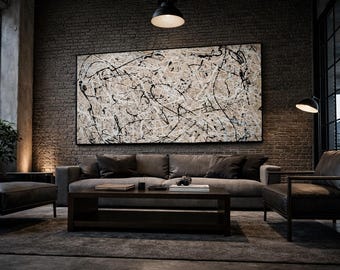 May include: An abstract painting with black and white paint splatters hangs above a gray sofa in a modern living room. The room features a brick wall, a dark wood coffee table, and leather armchairs. The lighting is dim, creating a moody atmosphere.