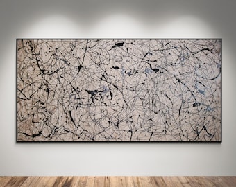 May include: Abstract expressionist painting with a black frame. The artwork features a beige background with black paint splatters and lines. The painting is displayed on a white wall above a wooden floor.