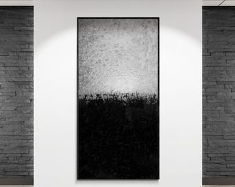 May include: Abstract black and white artwork in a black frame. The painting is divided horizontally, with a textured white upper section and a dark, textured black lower section. The artwork is displayed on a white wall.