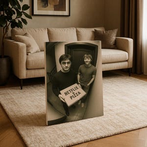 May include: A sepia-toned print showing two people holding a pizza box with the words "Netflix & Pizza." The print is displayed in a living room with a beige sofa, rug, and abstract artwork on the wall.