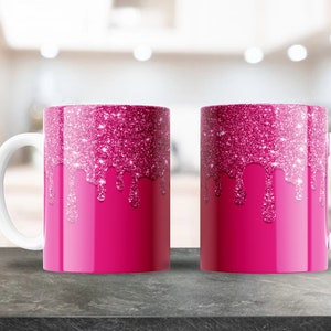 Könnte beinhalten: Zwei rosa Keramikbecher mit einem glitzernden rosa Tropfendesign. Die Becher haben weiße Henkel.
