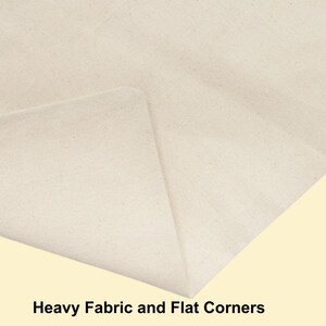 May include: A close-up view of off-white, heavy-weight canvas fabric featuring a folded corner that creates a sharp, flat edge. The material has a visible, dense weave texture throughout, and the text "Heavy Fabric and Flat Corners" is printed below.