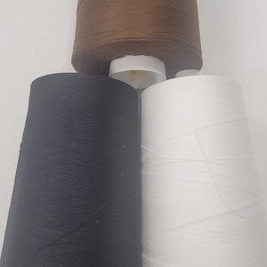 May include: Three spools of thread, one brown, one black, and one white.