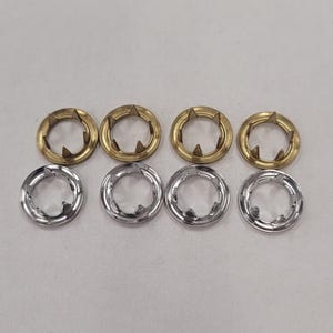May include: A set of six metal snap fasteners, three in gold and three in silver. The fasteners are round with a star-shaped center.