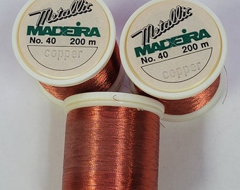 May include: Three spools of metallic copper thread, each labeled "Metallic Madera No. 40 200 m copper".